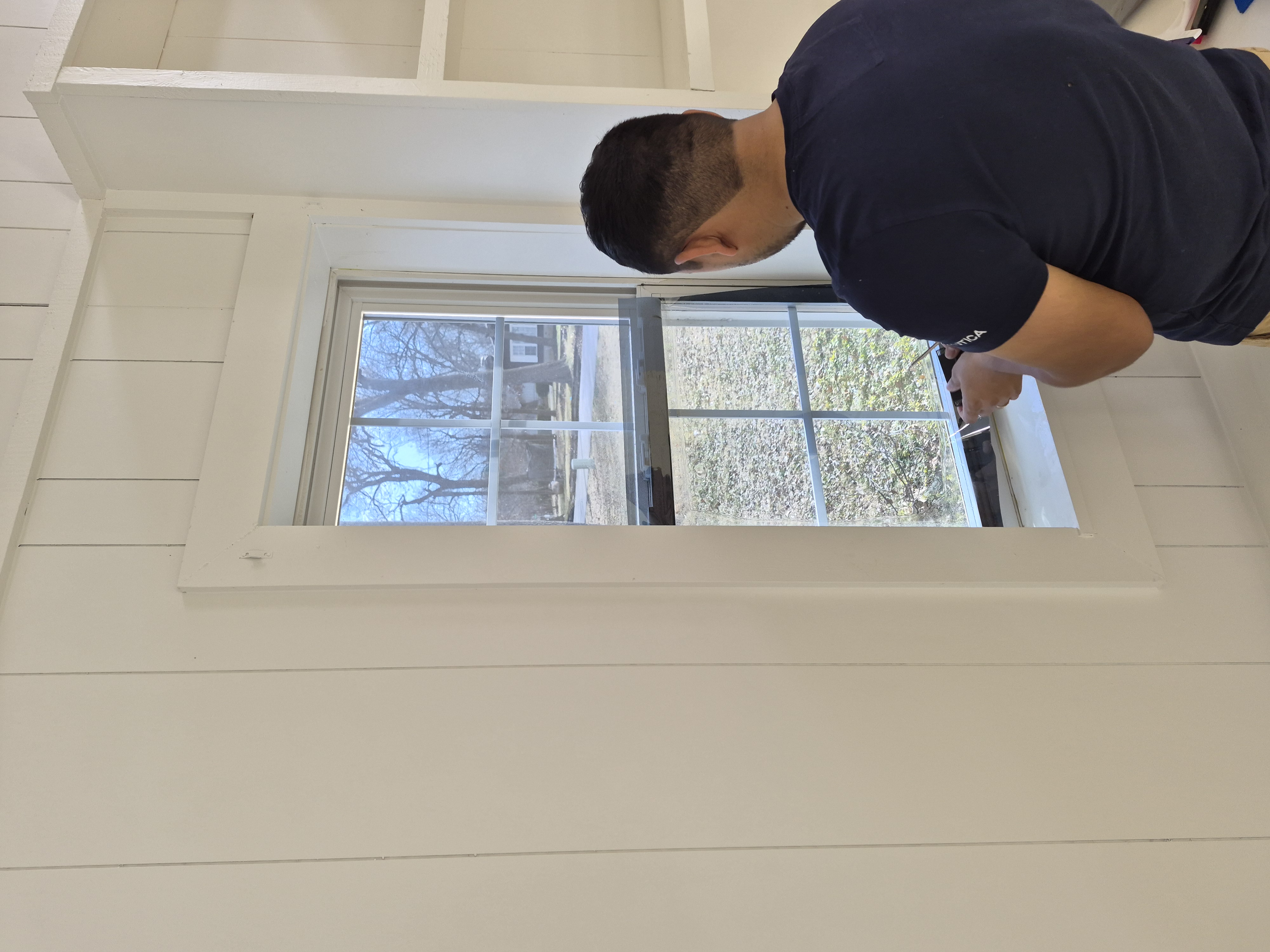 Installer applying window tint film to residential window